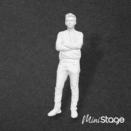 Figure of a male standing wearing jeans and a jumper, with his arms folded